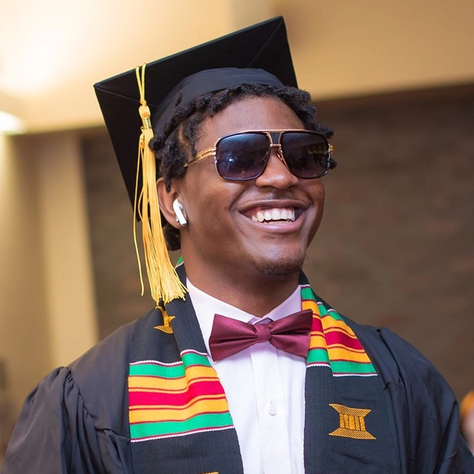 Happy graduate wearing graduation gown and cap